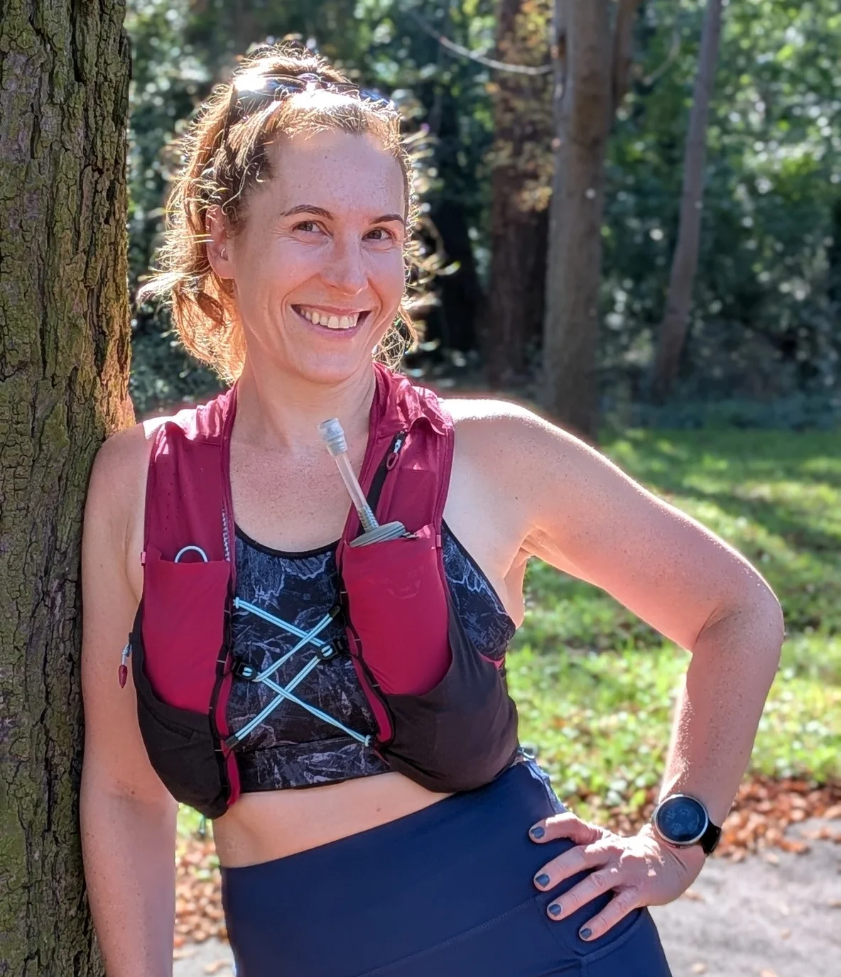 Marion lehnt an einem Baum und lächelt in die Kamera.