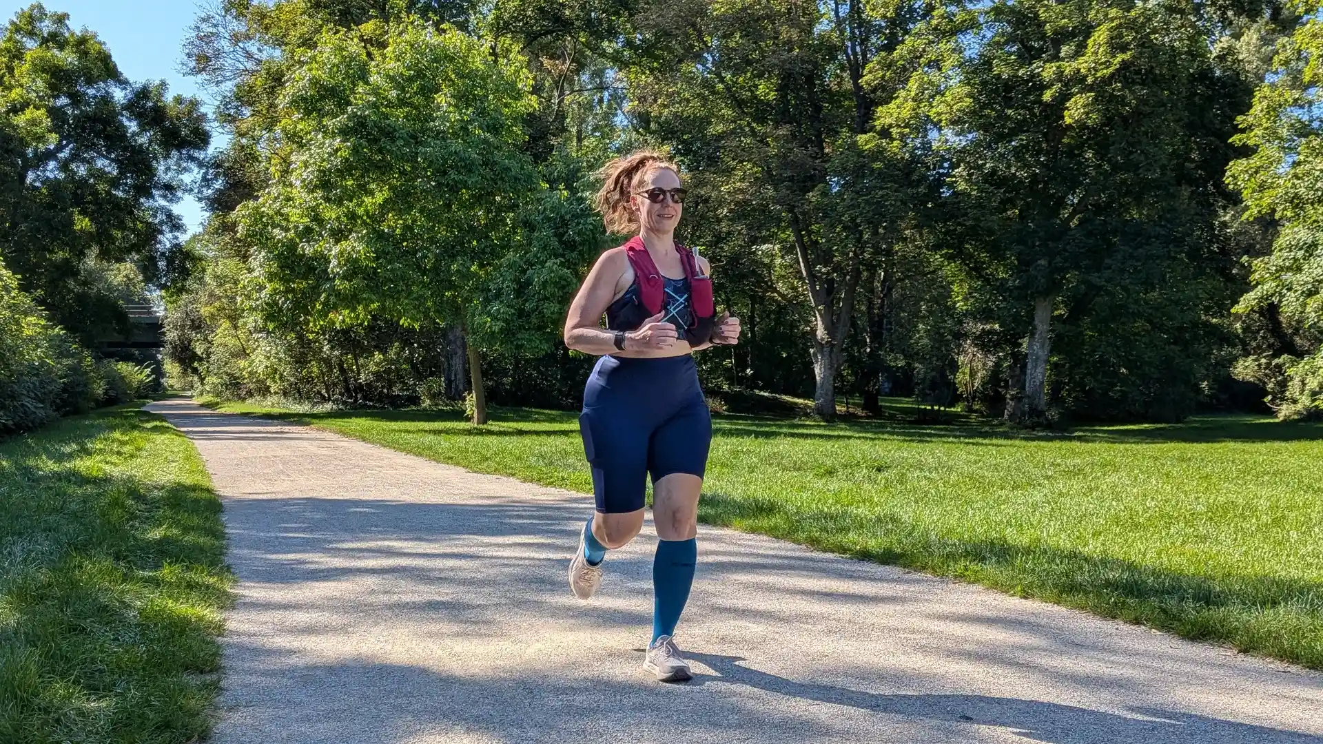Marion läuft auf einem Weg durch eine sonnige Wiese.